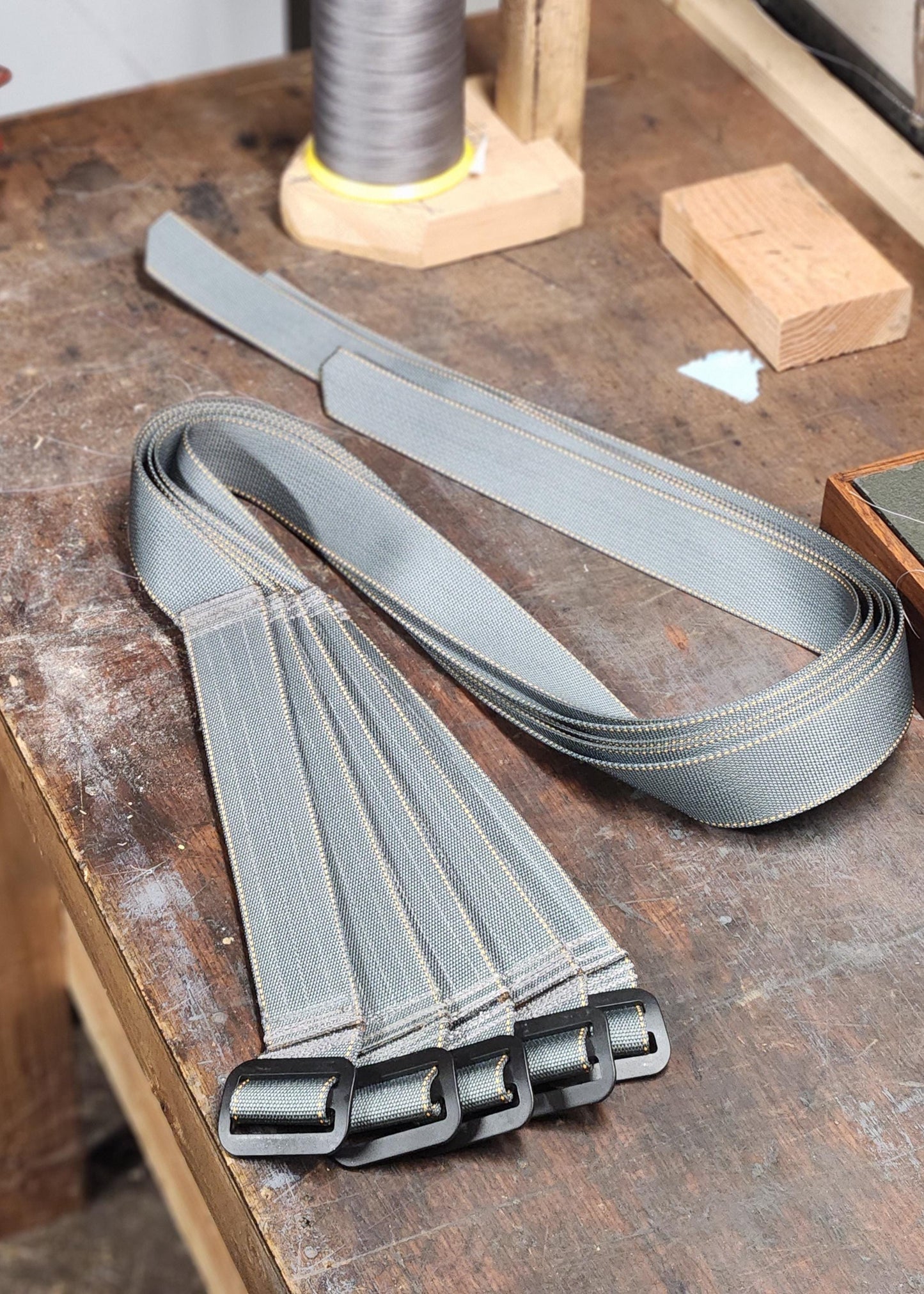 Group of gray Advanced CCW belts for appendix carry on workbench.